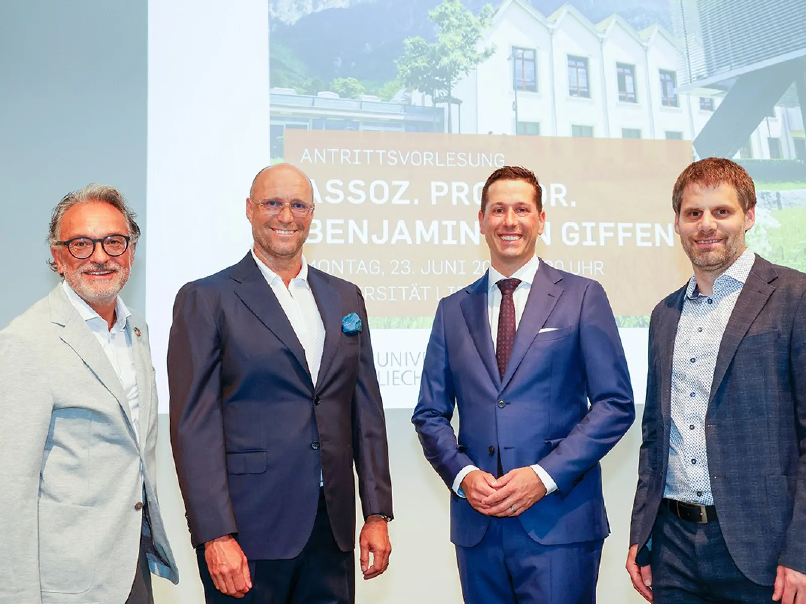 Foto von Assoz. Prof. Dr. Benjamin van Giffen während seiner Antrittsvorlesung an der Universität Liechtenstein, umgeben von Dr. Christian Frommelt, Rektor der Universität, Dr. Gunter Beitinger von Siemens und Karsten Neugebauer von VIQTORIOUS AG, die alle die Bedeutung digitaler Innovationen hervorheben.