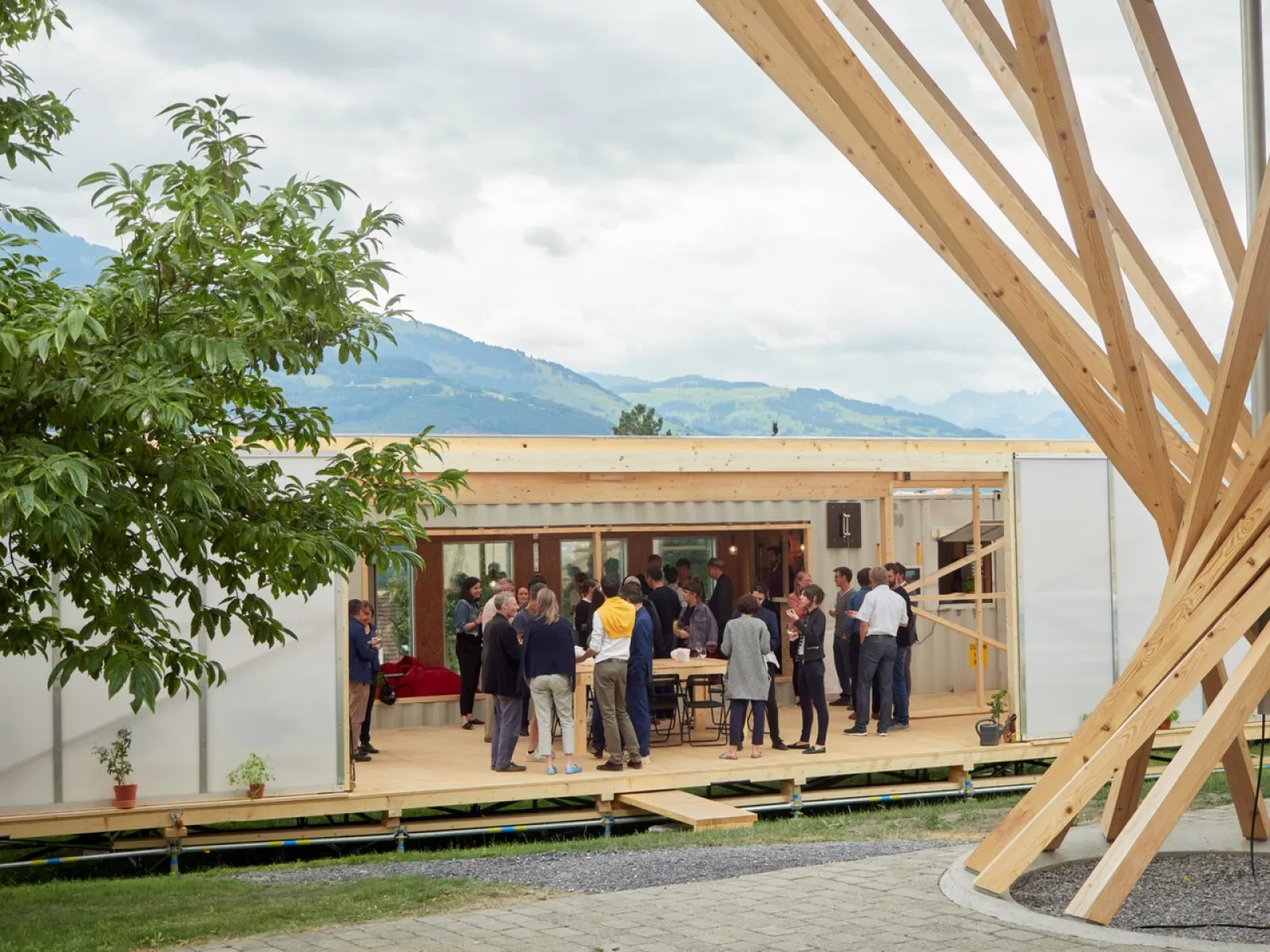 Aussenansicht des Base Camps, mit mehreren Menschen die davor stehen.