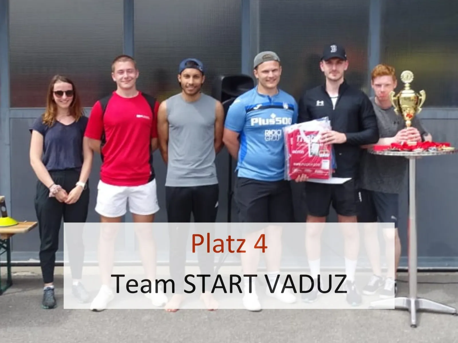 Gruppe von sechs Personen steht nebeneinander vor einer Wand. Eine Person hält einen Pokal. Text im Bild: "Platz 4 Team START VADUZ".