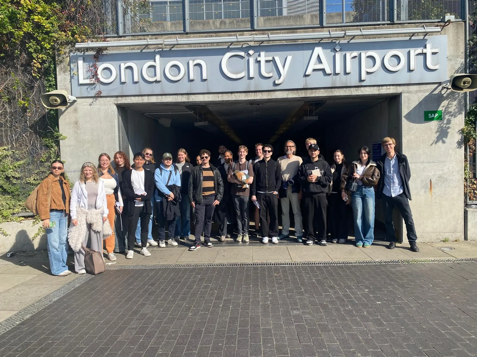 Gruppenbild mit dem Schriftzug "London City Airport" im Hintergrund