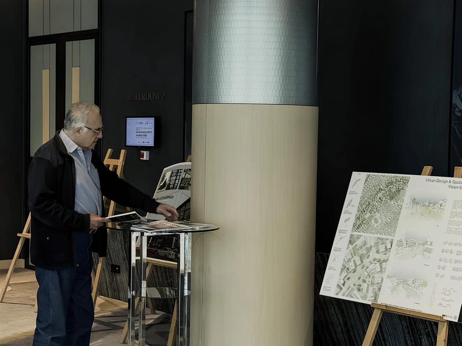 Mann schaut auf Architekturplan, der auf Staffelei steht