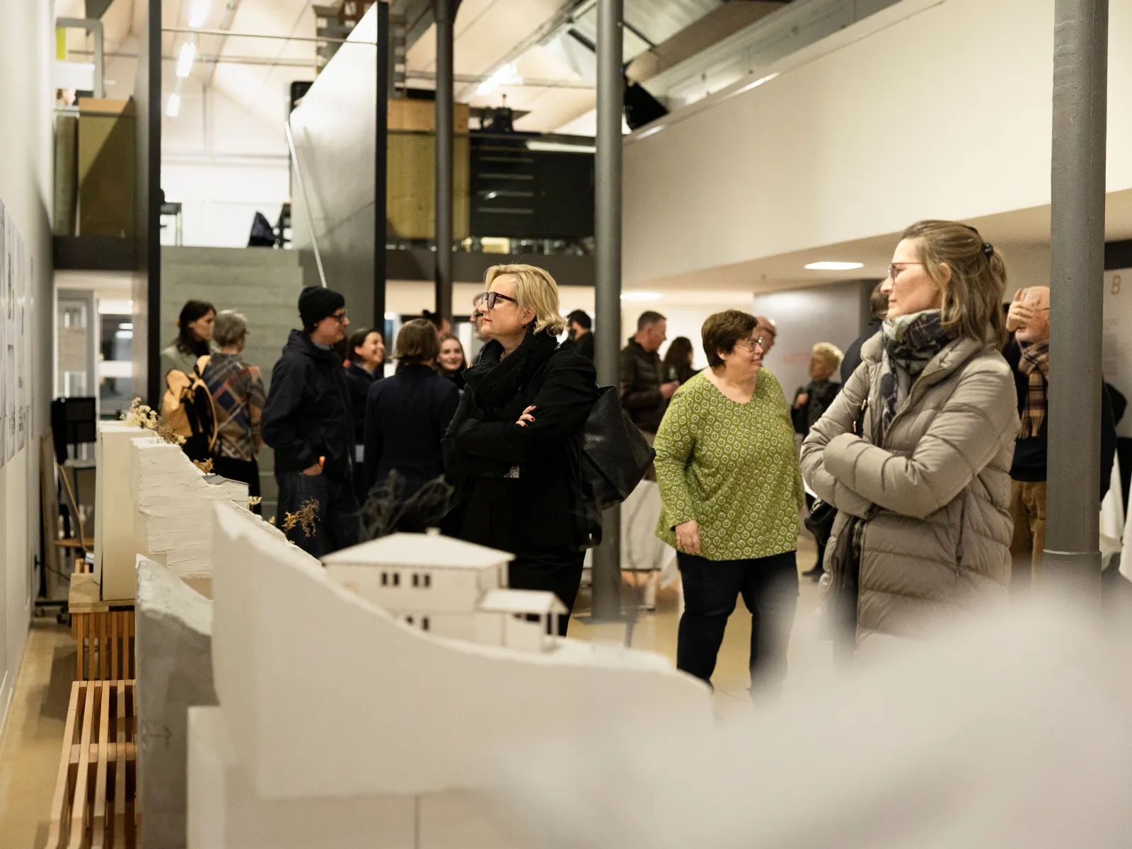 Mehrere Menschen bei der Ausstellung einer Architekturausstellung