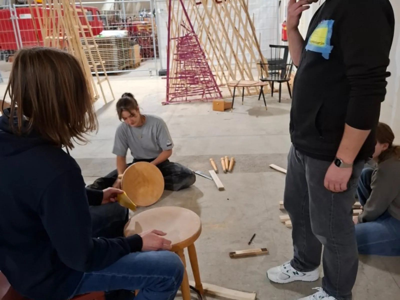 Mehrere Jugendliche in einer Halle arbeiten handwerklich