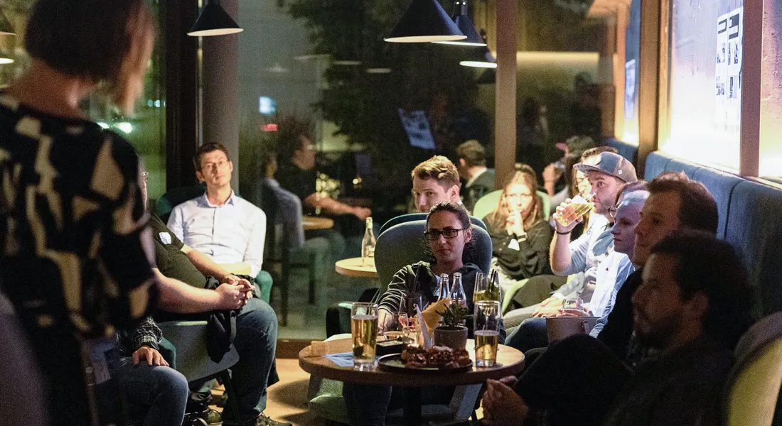 Studierende und Alumni bei informellem Networking Abend in gemütlicher Atmosphäre mit Getränken und Gesprächen