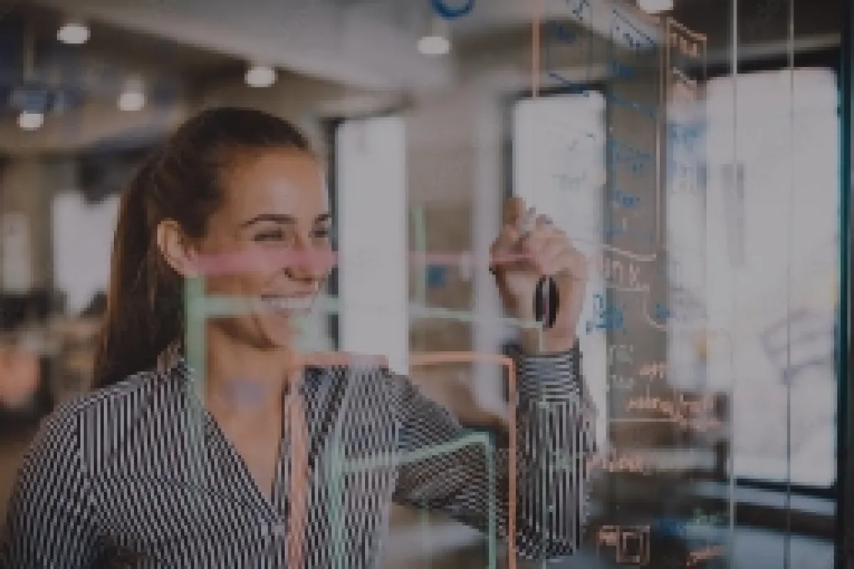 Eine Frau schreibt an eine Scheibe mit dem Schriftzug "Forschung"