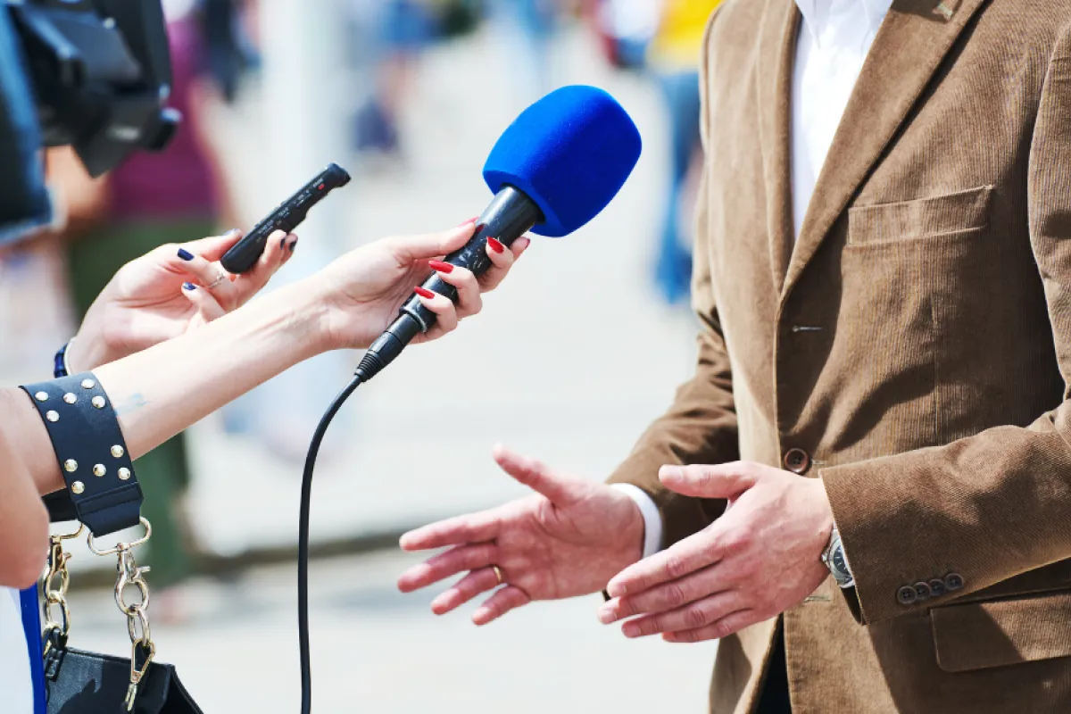 Ein Mann spricht mit einem Reporter.