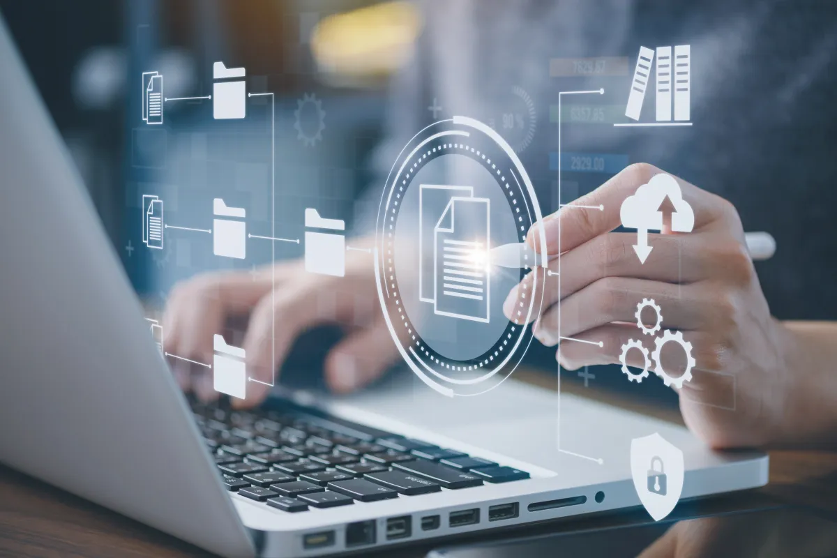Digitale Aktenstruktur auf Laptopdisplay, Person interagiert mit Symbolen für Dokumente, Cloud und Sicherheit.