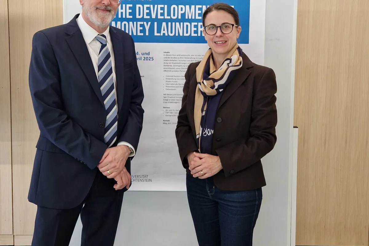 Zwei Personen stehen vor einem Poster des Intensivkurses „The Development of Money Laundering“ an der Universität Liechtenstein.