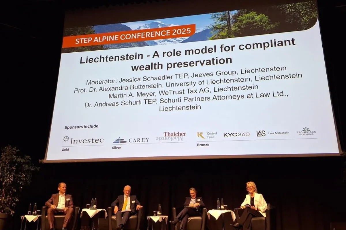 Podiumsdiskussion bei der STEP Alpine Conference 2025 mit vier Expertinnen und Experten auf einer Bühne vor einer großen Leinwand, die das Thema „Liechtenstein – A role model for compliant wealth preservation“ zeigt.