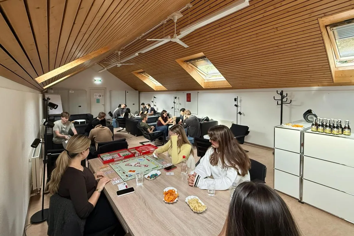 Mehrere Studierende sitzen in einem Raum und spielen