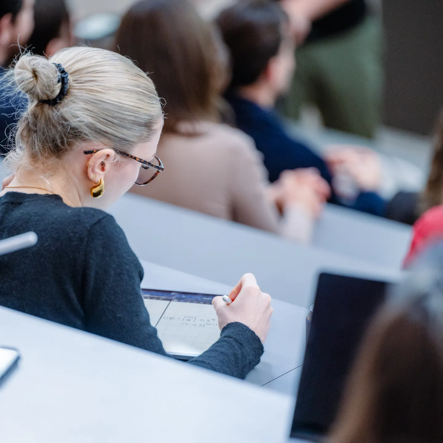 Eine Studentin macht sich digitale Notizen auf einem Tablet während einer Vorlesung an der Universität Liechtenstein.