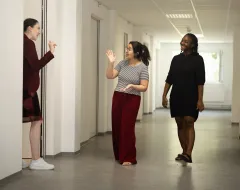 Studentinnen lachen und unterhalten sich im Flur des Studierendenwohnheims der Universität Liechtenstein.