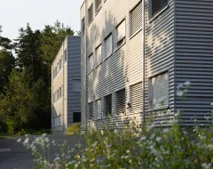 Seitenansicht des Studierendenwohnheims der Universität Liechtenstein mit umliegender Natur.