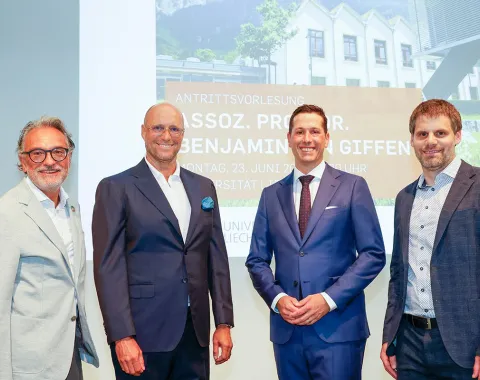Foto von Assoz. Prof. Dr. Benjamin van Giffen während seiner Antrittsvorlesung an der Universität Liechtenstein, umgeben von Dr. Christian Frommelt, Rektor der Universität, Dr. Gunter Beitinger von Siemens und Karsten Neugebauer von VIQTORIOUS AG, die alle die Bedeutung digitaler Innovationen hervorheben.