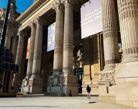 Außenansicht des Grand Palais in Paris mit imposanten Säulen und Bannern, aufgenommen bei sonnigem Wetter. Ort des Forum Bois Construction 2025, das sich auf klimaschonendes Bauen konzentriert.