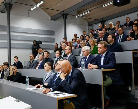 Ein vollbesetzter Hörsaal an der Universität Liechtenstein, in dem Studierende und Fachleute aufmerksam einer Präsentation folgen.
