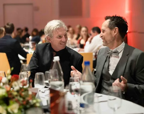 Lachende-Männer-am-Tisch-Uniball-Uni-Liechtenstein