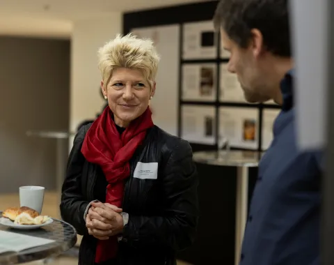 Frau mit kurzen, blonden Haaren und rotem Schal