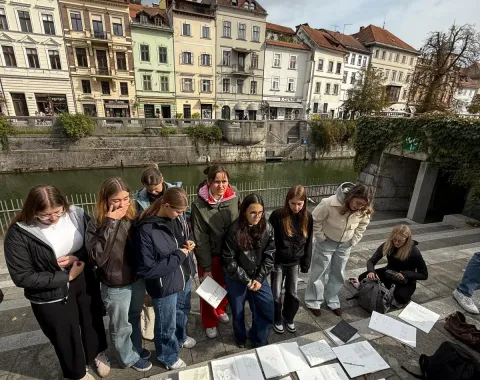 Junge Menschen vor Skizzen mit Häusern im Hintergrund
