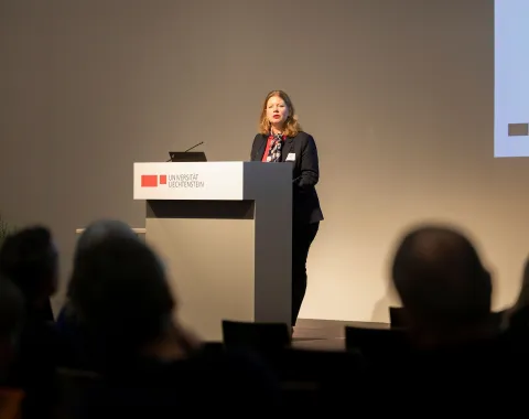 Eine vortragende Person auf einer Bühne 