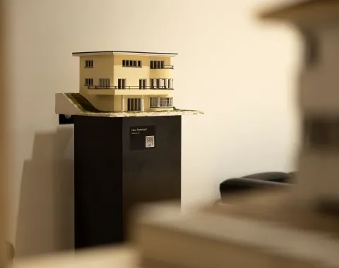 Ein beiges Architekturmodell auf einem schwarzen Ausstellungsbock