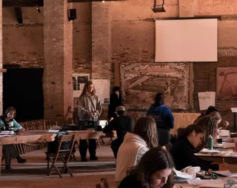 Mehrere arbeitende Studierende in einer alten Halle 