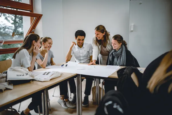 Studierende der Universität Liechtenstein arbeiten gemeinsam an einem Projekt im Seminarraum