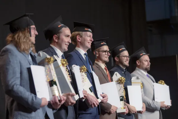 Absolventen mit Urkunden und Graduierungshüten bei der Abschlussfeier der Universität Liechtenstein
