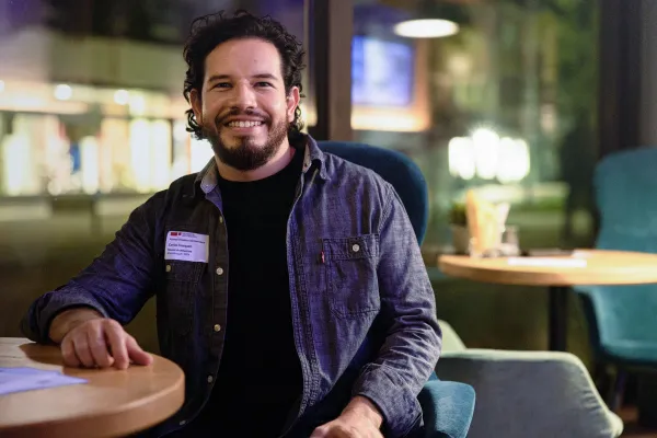 Lachender Teilnehmer des Alumni Treffens der Universität Liechtenstein in entspannter Abendatmosphäre