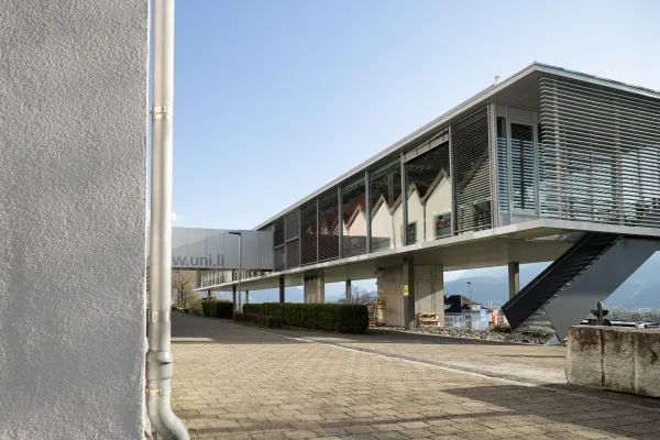 Moderne Architektur mit Glasfassade und Verbindungselementen auf dem Campus der Universität Liechtenstein.