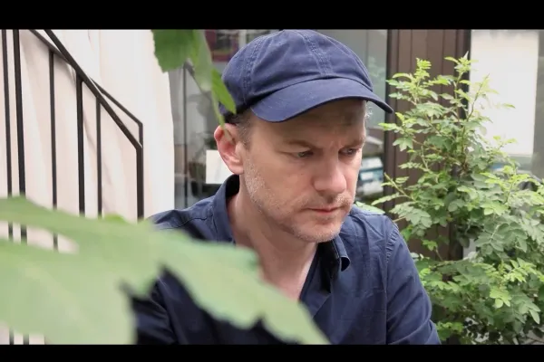 Frontaufnahme eines Mannes mit blauer Kleidung und blauer Mütze